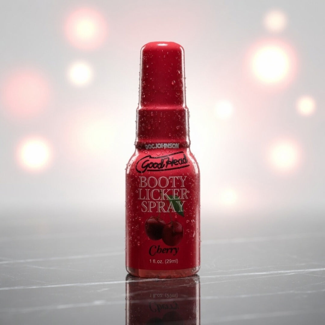 Red bottle of 'Booty Licker Spray' with cherry flavor on a reflective surface.