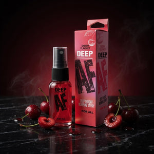 Red spray bottle and packaging with cherries on a dark surface