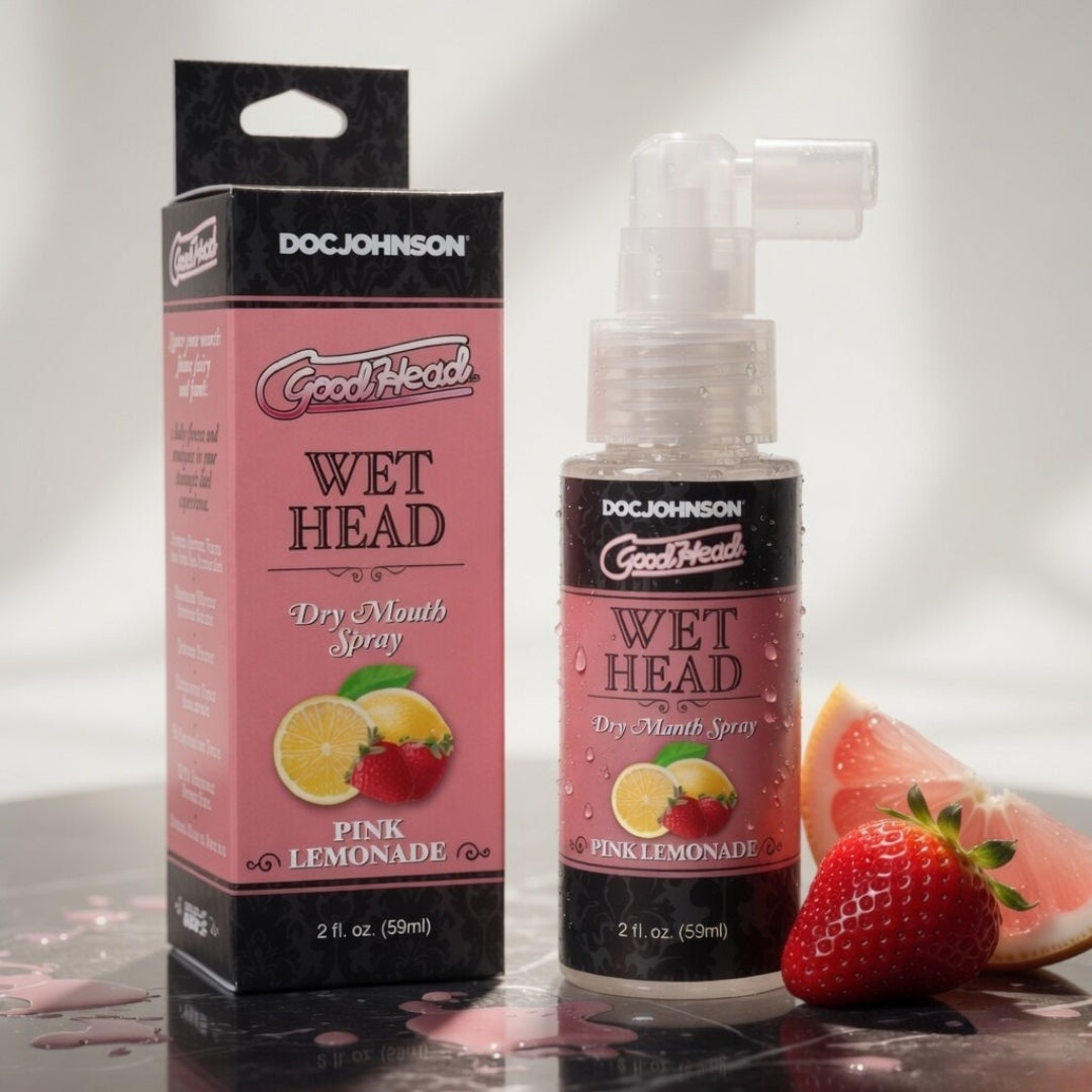 Doc Johnson GoodHead Wet Head Dry Mouth Spray packaging and bottle with pink lemonade flavor on a reflective surface.