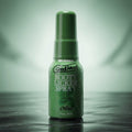 Green bottle of Goodhead Booty Licker Spray on a reflective surface with a gradient background