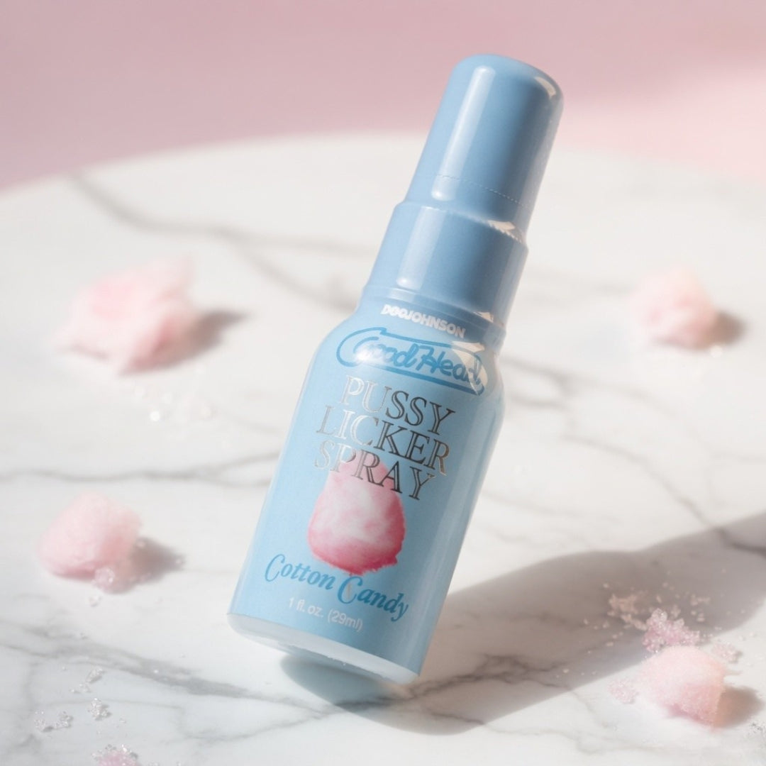 Blue bottle of 'Fluffy Licker Spray' with cotton candy flavor on a light pink background