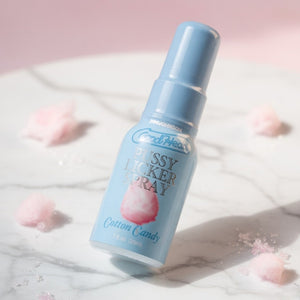 Blue bottle of 'Fluffy Licker Spray' with cotton candy flavor on a light pink background