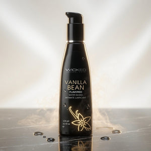 Black bottle of Wicked Vanilla Bean flavored lubricant on a reflective surface with a gradient background.