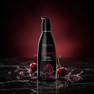 Black bottle of Wicked Cherry flavored lubricant with cherries on a dark background