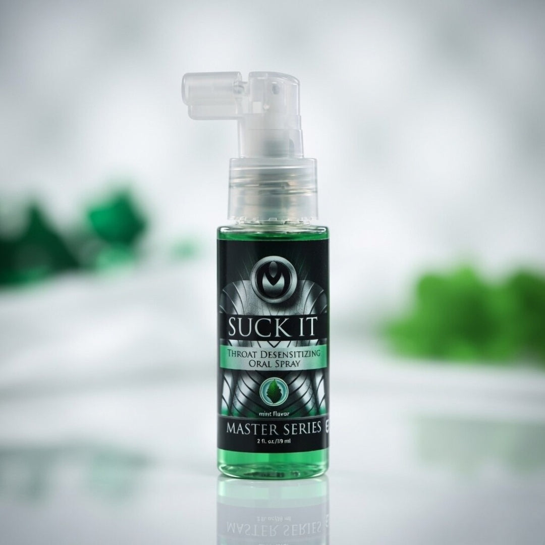 Spray bottle labeled 'Suck It' on a reflective surface with a blurred green background