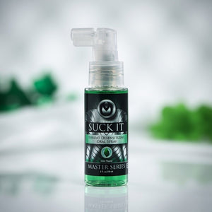 Spray bottle labeled 'Suck It' on a reflective surface with a blurred green background