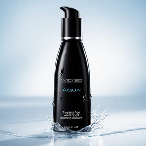 Black bottle of Wicked Aqua lubricant with water splash on a light blue background